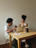 Couple talking in front of laptop.