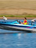 Man driving a boat across a lake