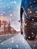 Car driving on road in snowy weather.