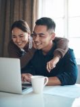 Smiling couple looking at laptop.