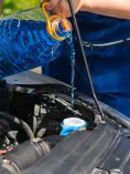 Person adding windshield washer fluid to car.