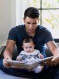 Dad reading book to baby.