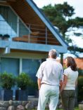 Couple looking at outside of A-frame house.