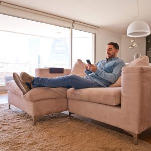 Middle-aged man sitting on sofa in apartment.