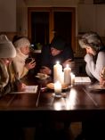 People gathered around candles and bundled up.