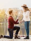 Man on one knee proposing to woman.