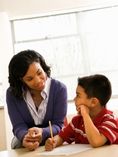 Mom sitting with son over homework.
