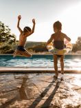 Kids jumping in pool.