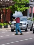 Man walking with his head in a cloud across the street while on his cellphone