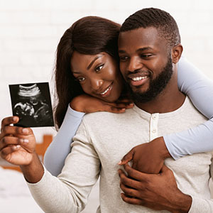 Black couple looking at sonogram picture of baby.