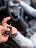 one person handing car key to another.
